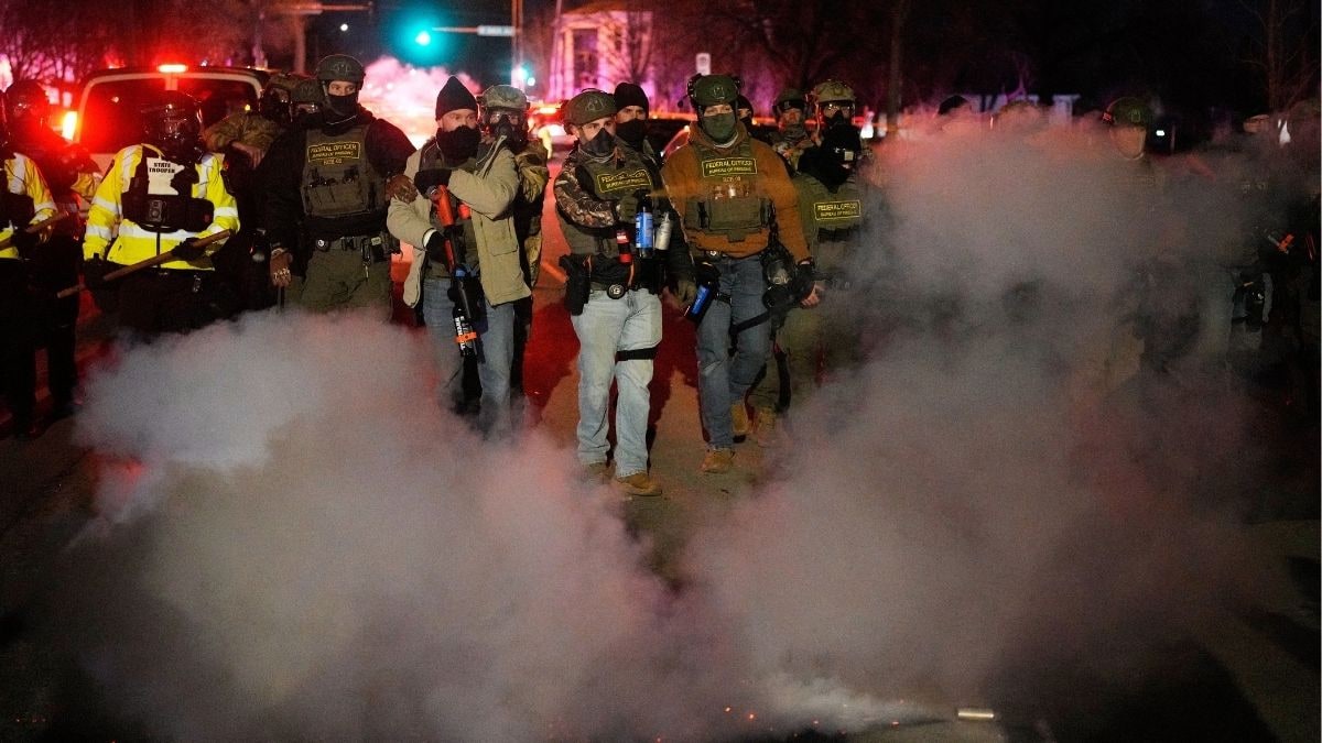 A federal law enforcement officer deploys pepper spray during a protest after a shooting in Minneapolis | AP