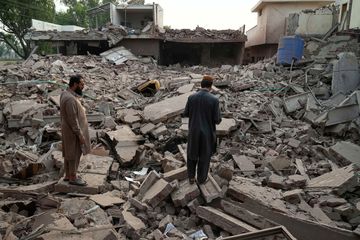 Local residents walk through the rubble of a building damaged by Indian missile attack in Muridke In Pakistan | AP 